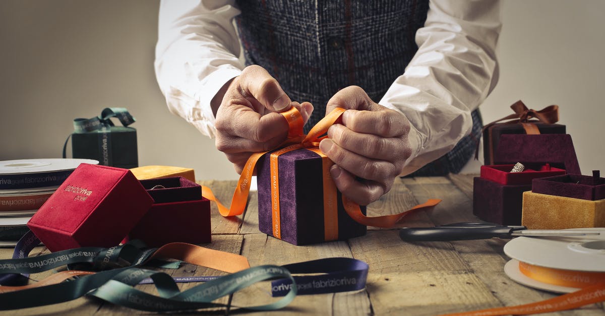 How Exactly Does the Ghost of Christmas Present Work? - Person Tying Ribbon on Purple Gift Box