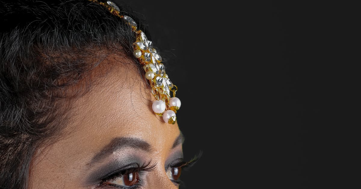 How is the Black Pearl caught up? - Woman with White Pearl Accessory on Forehead