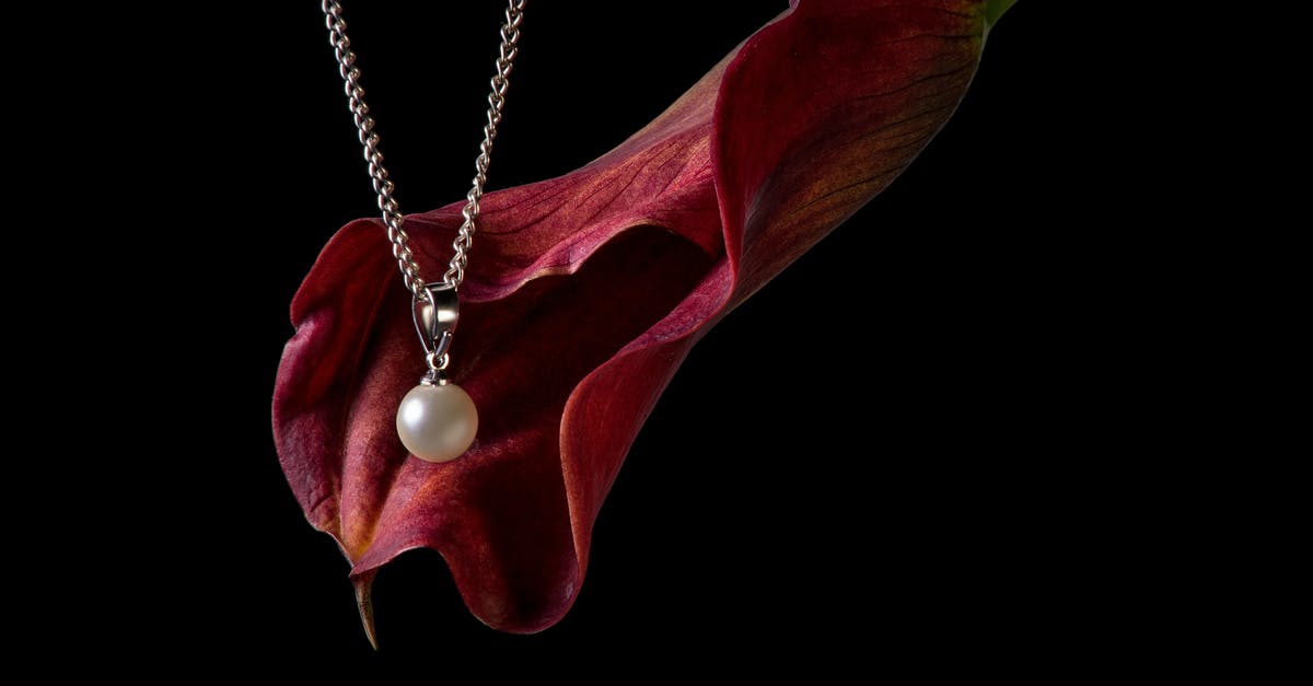 How is the Black Pearl caught up? - A Pearl Necklace Beside a Red Arum Lili