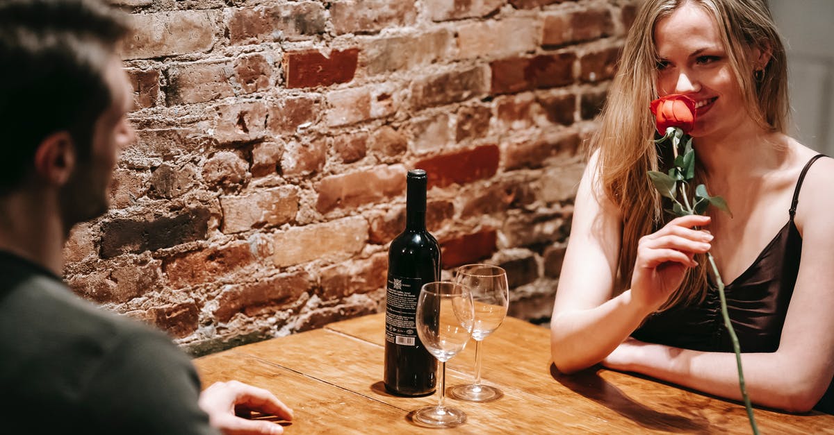How long did Rose and Jack know each other for? - Young couple in elegant clothes sitting at wooden table near brick wall in light restaurant while enjoying date with red rose and wine near glasses and looking at each other