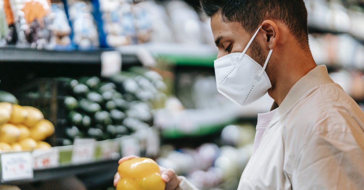 How many face expressions did Kubo have? - Side view of Indian male buyer in medical mask standing with yellow bell pepper in hand near stall with various vegetables on blurred background