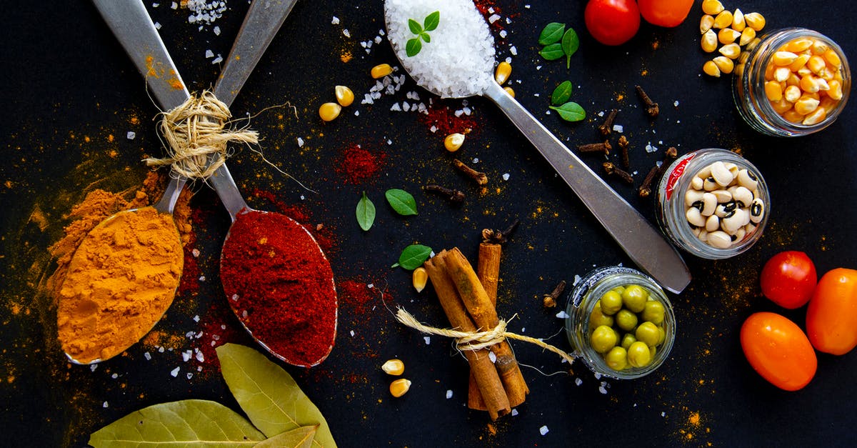 How many languages does Oliver Queen speak? - Top view of dry turmeric and paprika near bay leaves with cinnamon sticks and sea salt in spoons near jars with popcorn grains and olives with ripe colorful cherry tomatoes