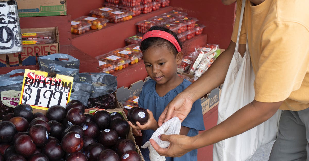 How many options actually exist? - Ethnic girl choosing fruit in market with mother