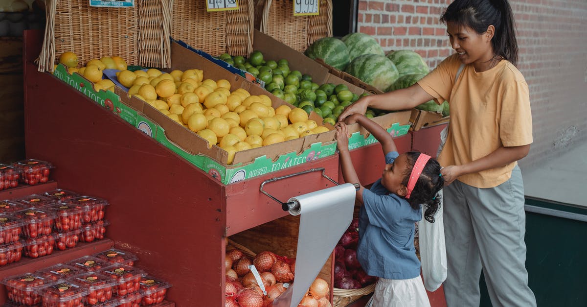 How many options actually exist? - Small ethnic girl taking fruits from box with mother