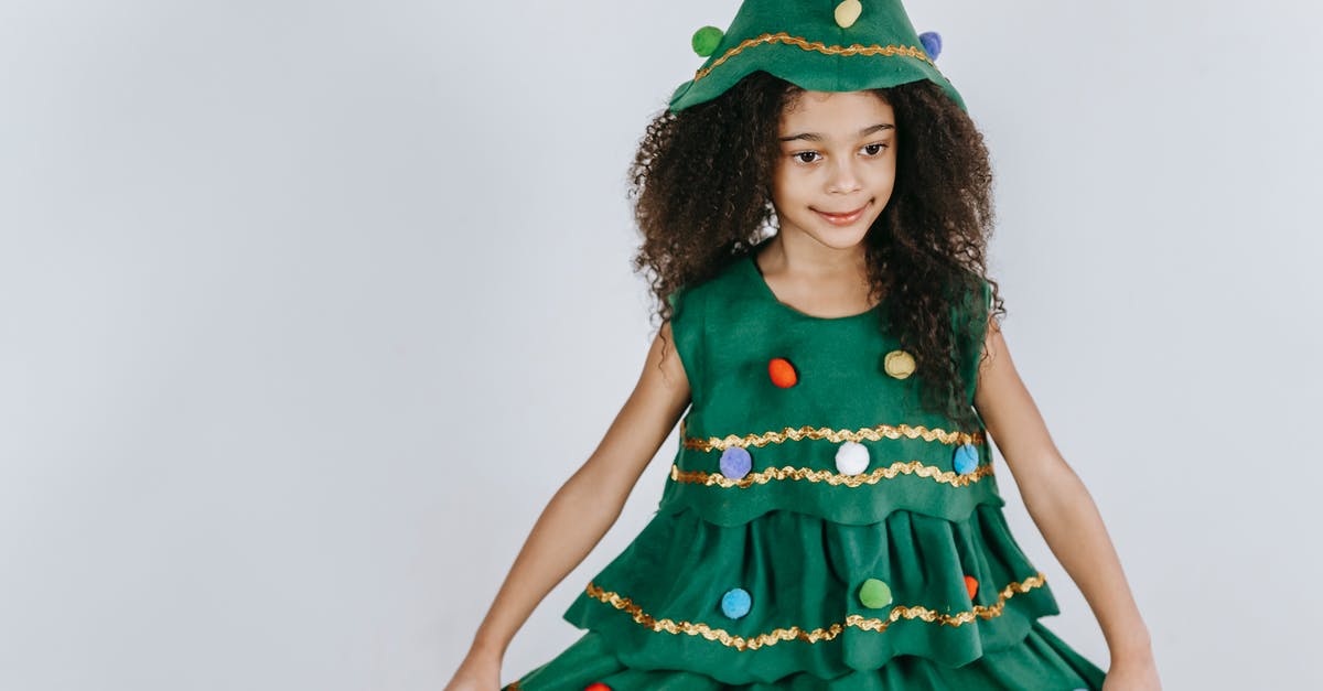 How many years have passed between season 5 and 6 of The Americans - Cheerful African American girl wearing creative Christmas tree costume and hat touching skirt and looking away in light studio