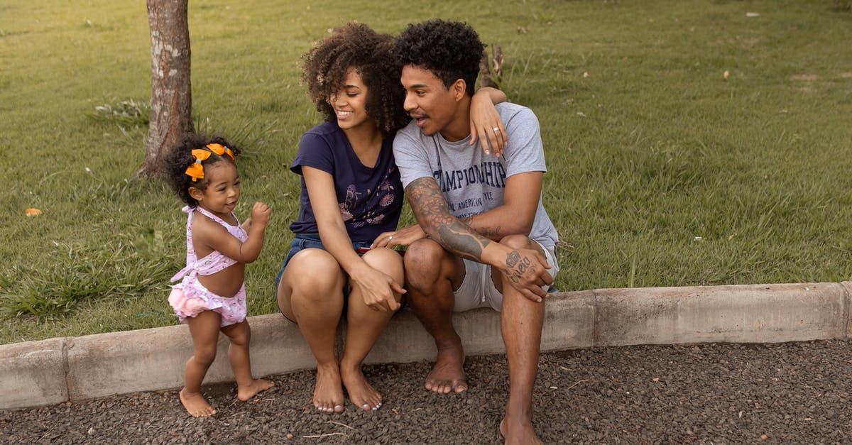 How much did the parents know in season 1 of The Sinner? - Cheerful African American mother and father with cute little daughter on kerb near lawn with verdant grass in daytime