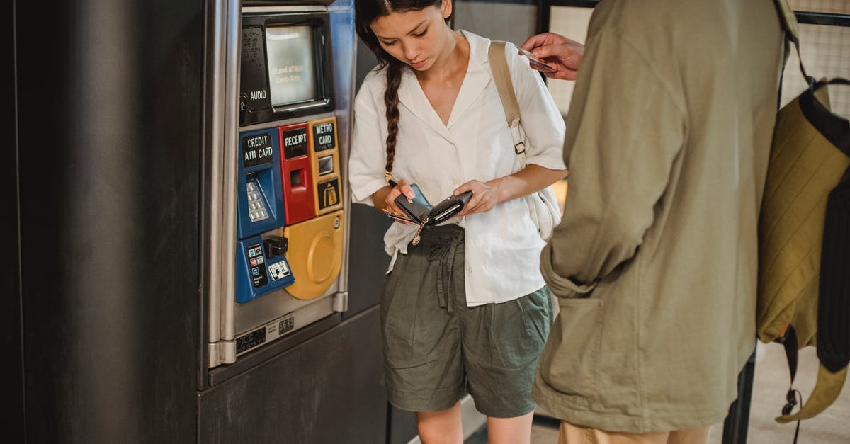How much do 3D ticket prices affect gross revenue? - Calm young couple wearing casual clothes standing together near ticket vending machine with wallet in hands in underground