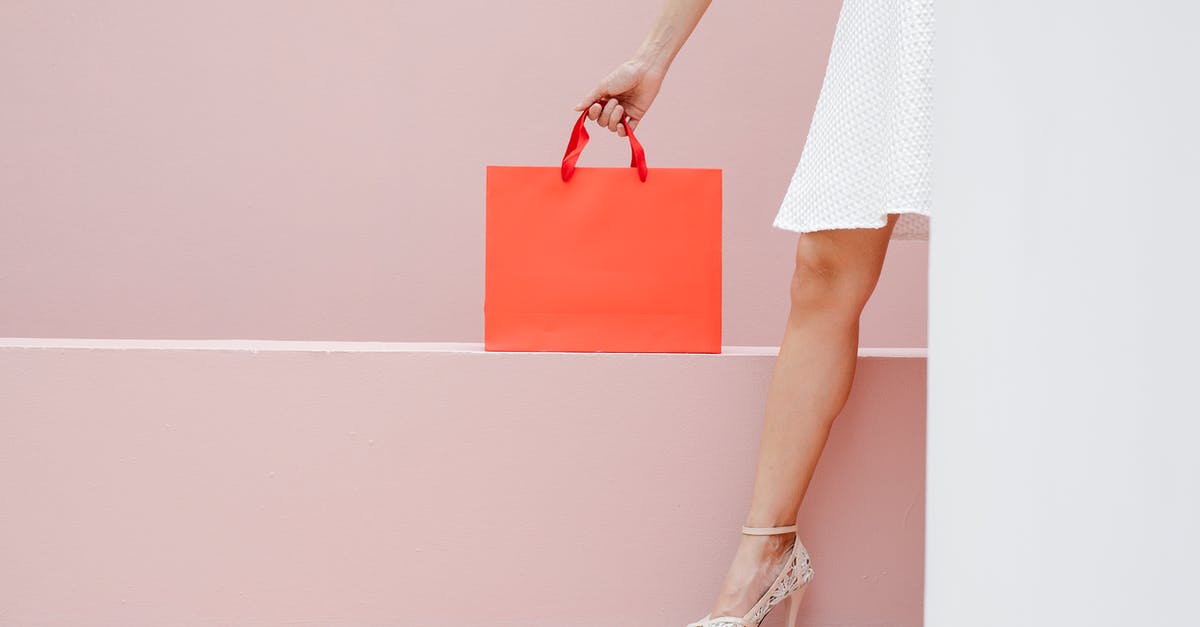 How much money did Jason Bourne have in the red bag during Bourne Identity? - Crop anonymous stylish female in white dress and high heels carrying red shopping bag against pink wall