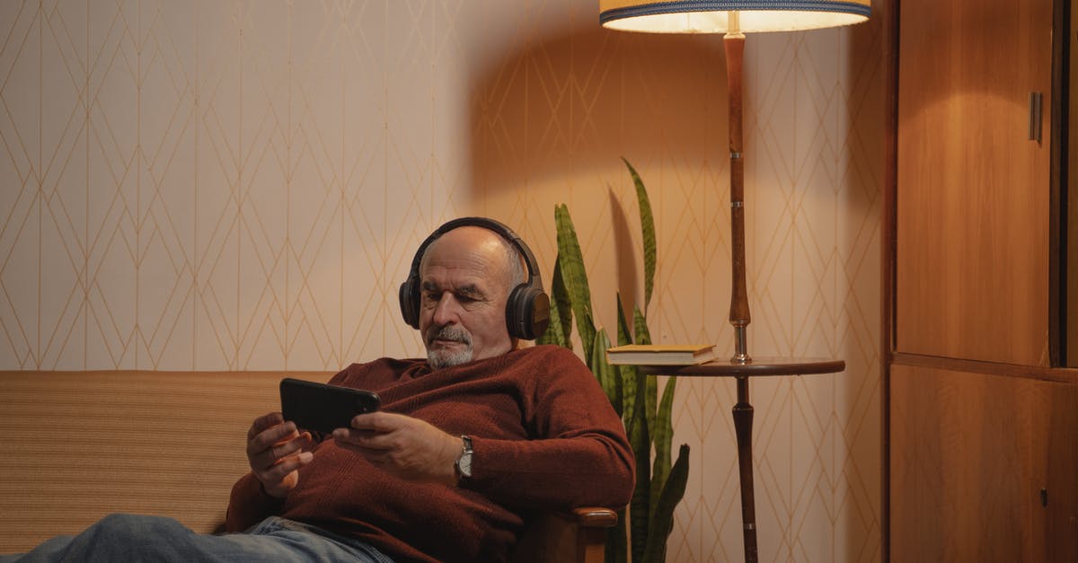 How old is Adam in The Goldbergs? How does this reconcile with watching Star Wars? - An Elderly Man with Headphones Using a Smartphone while Sitting on the Sofa 
