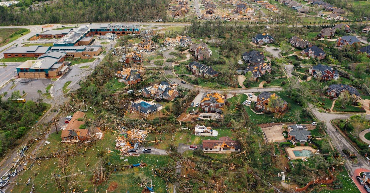 How realistic is the tornadoes in Into the storm 2014 - Aerial view of tornado impact on small settlement cottages with destroyed roofs windthrown trees and bent electricity transmission lines