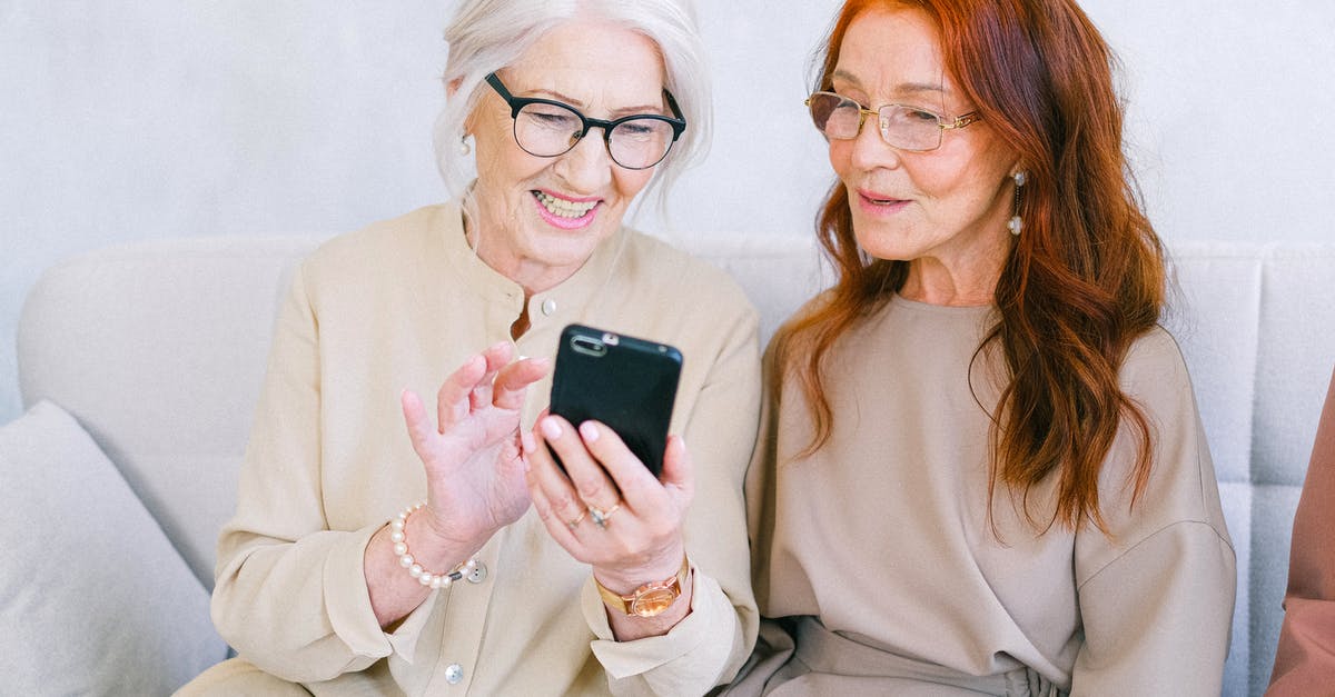 How the new Omnitrix watch connected to the old Ultimatrix plot? - Happy elderly elegant trendy women looking at screen of mobile phone and shopping online while resting on sofa
