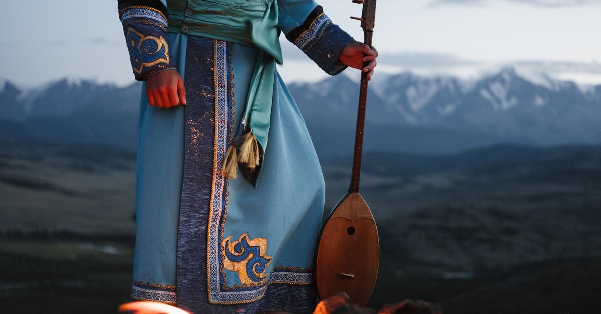 How to describe the music that appears in the background of EVERY Egyptian related scene? - Crop person standing near bonfire with Mongolian folk instrument in valley