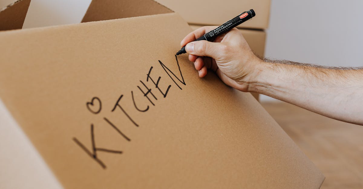 How to identify a Nietzschean? - Crop unrecognizable male using marker to write on carton box word kitchen and draw cute heart while packing kitchenware before relocation