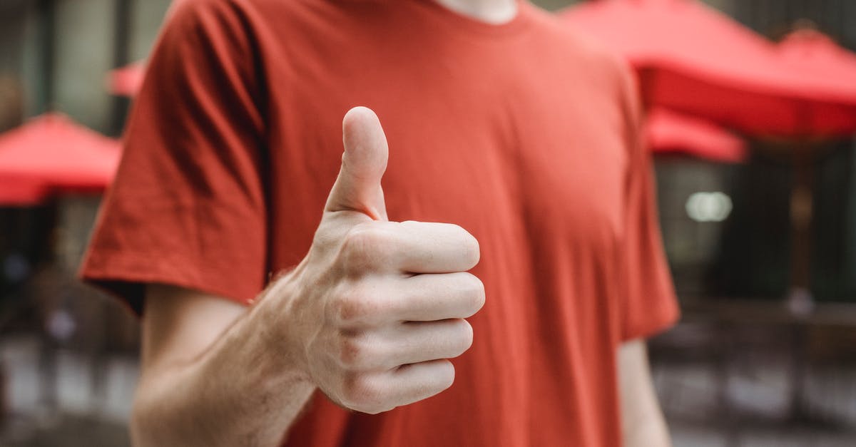 How to obtain a good version of Pinocchio? - Crop anonymous young male in red t shirt showing thumb up gesture while standing on city street on sunny day