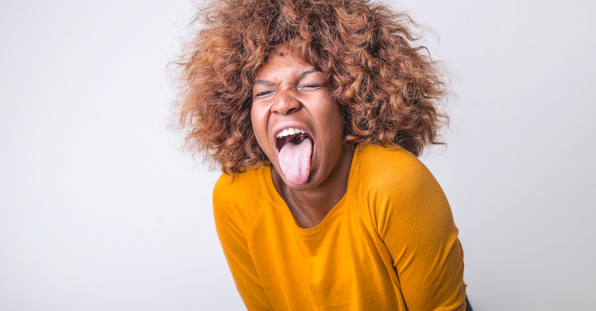 I'm searching for a 80s or 90s American movie about a crazy religious woman [closed] - Red haired African American female in vivid yellow sweater standing with eyes closed and tongue out against gray background in modern studio