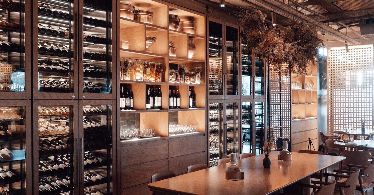In Kingsman: The Secret Service, what do the wine choices imply? - Wall with shelves with collection of assorted wine in modern restaurant with wooden furniture and creative decor