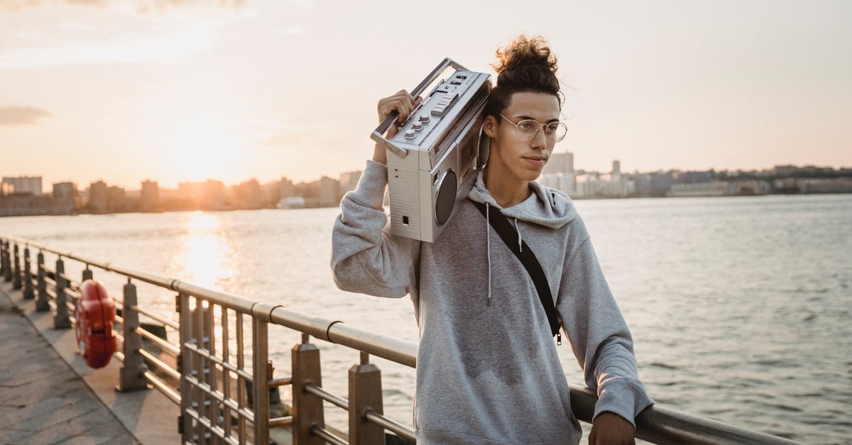 In Mystic River, How did listening to the 911 tape solve the case? - Positive ethnic man carrying boombox on shoulder on embankment
