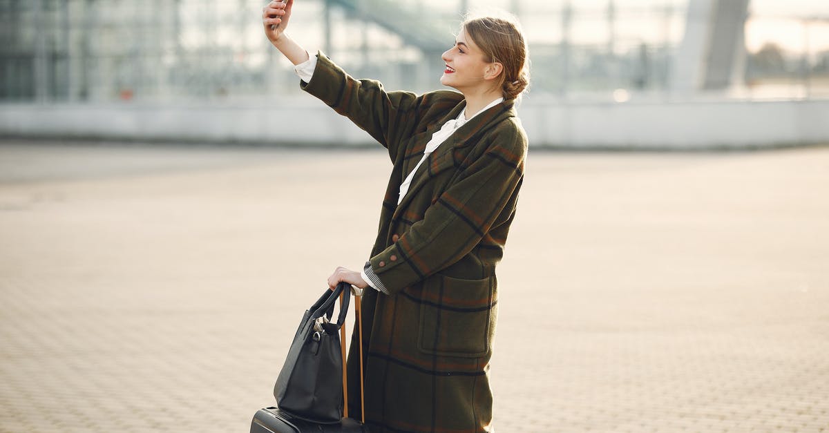 In Sex and the City how do the women actually make a living? - Stylish young woman with luggage taking selfie outside modern glass building