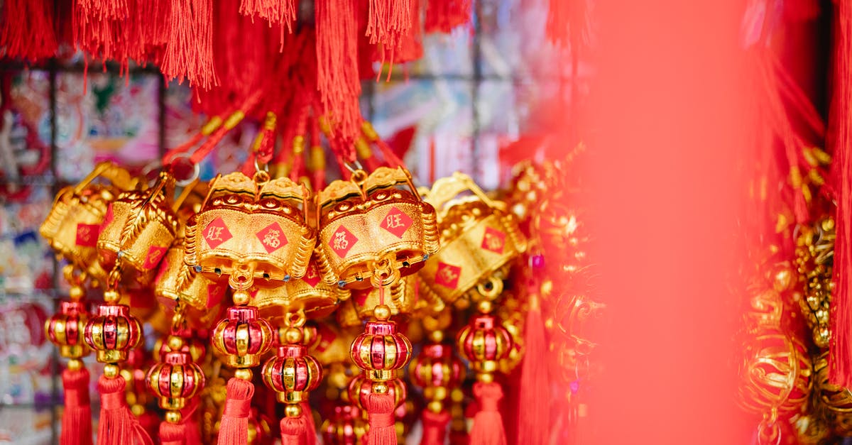 In Tenet, how is this character able to retrieve the original cache of buried gold? - Collection of red and golden Chinese hanging decorations with hieroglyphs for New Year celebration