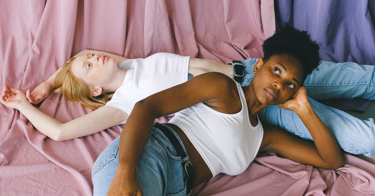 In The Color Purple how is it a black person can have so much wealth in the south? - Interracial Women Lying Down in Opposite Directions on Pink Textile