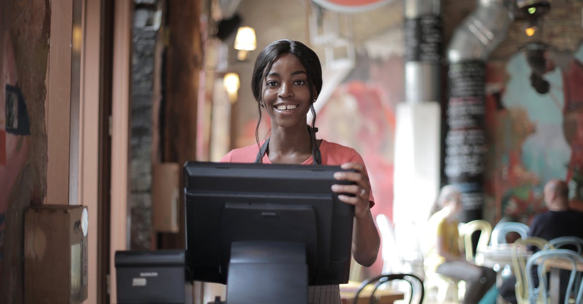 Is Black Museum trying to suggest there is a chronological order in Black Mirror? - Positive young woman in uniform smiling while standing at counter desk in  cafe