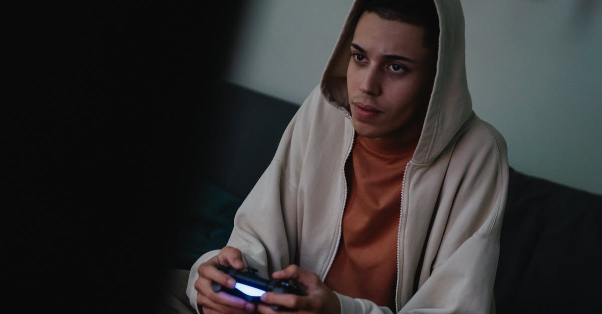 Is Dr. House of Dutch descent? - Addictive young ethnic male gamer in hoodie with console controller playing video game while looking forward at home