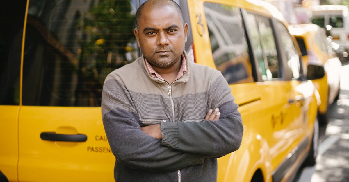 Is Glass self-explanatory? - Self confident ethnic taxi driver with crossed arms on street