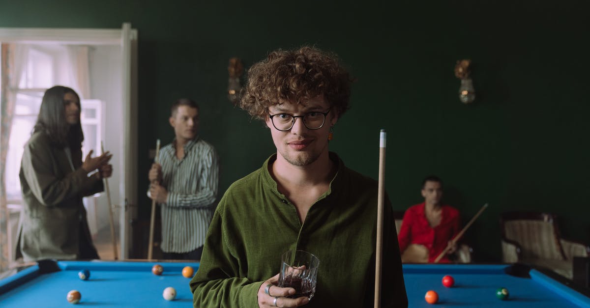 Is it a standard thing to challenge someone to best of 7 Games of Pool? - Man in Green Long Sleeve Shirt Holding Clear Drinking Glass