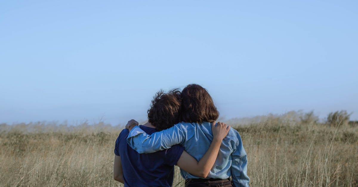 Is it implied that Stuart is homosexual? - Back view unrecognizable girlfriends wearing casual clothes hugging each other while standing on grassy vast field in summer countryside