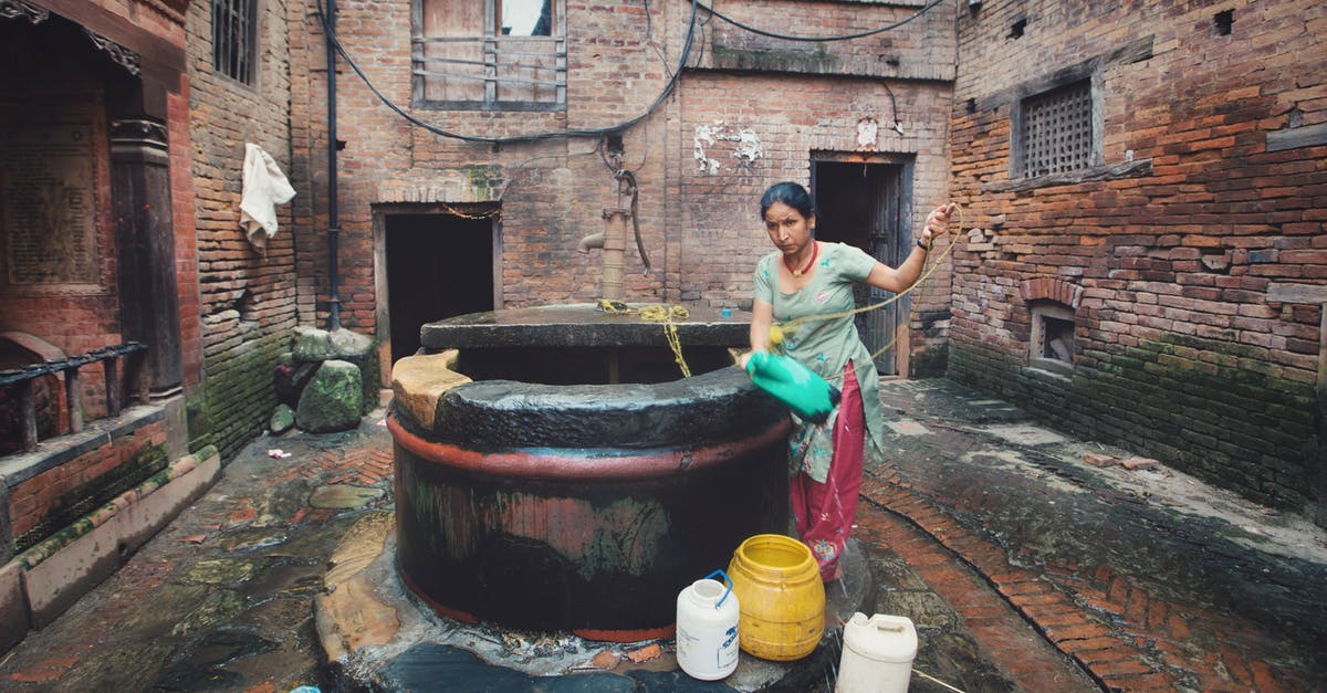 Is it realistic to build a well in the basement? - Ethnic woman pouring water in bucket