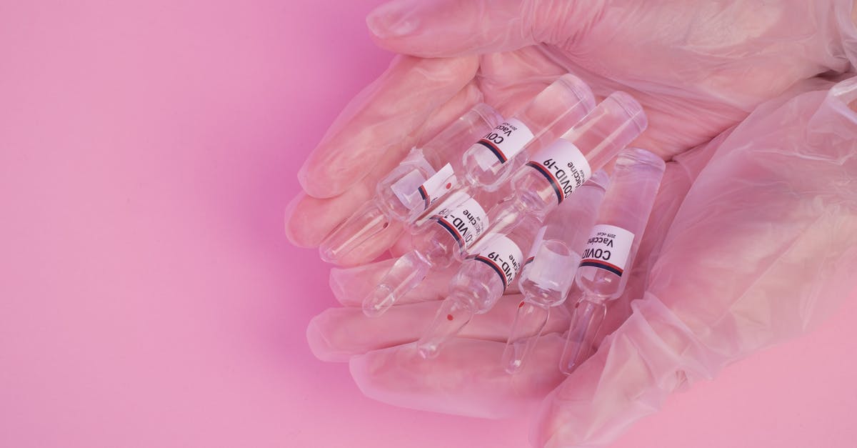 Is Lady Stoneheart's absence from the show explained? - Top view of crop faceless female doctor in latex gloves demonstrating heap of ampoules with COVID vaccine against pink background