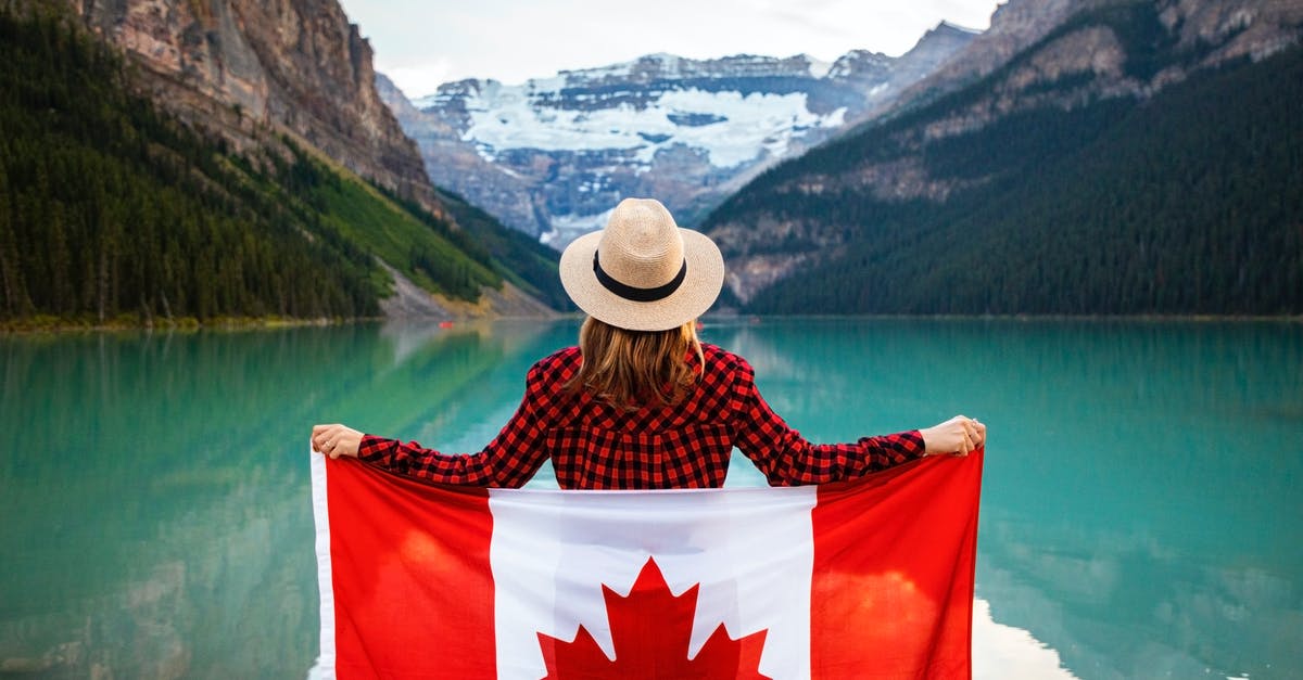 Is Louise Belcher ever depicted without her hat? - Woman Wearing Red and Black Checkered Dress Shirt and Beige Fedora Hat Holding Canada Flag Looking at Lake