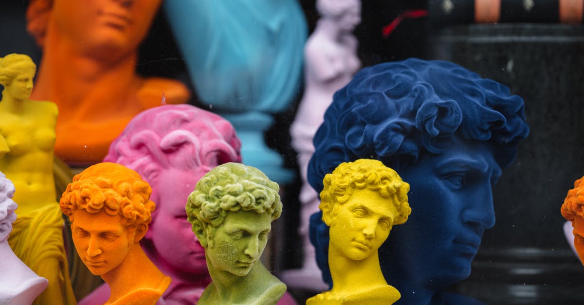 Is Lucifer a David Bowie Fan? - Collection of colorful head sculptures of David in different colors and shapes placed on counter in store with decorative souvenirs