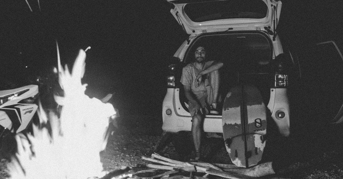 Is man capable of tearing off a car trunk lid as shown in U.N.C.L.E.? - Black and white bearded young man sitting in car trunk near surfboard and looking at bonfire at night