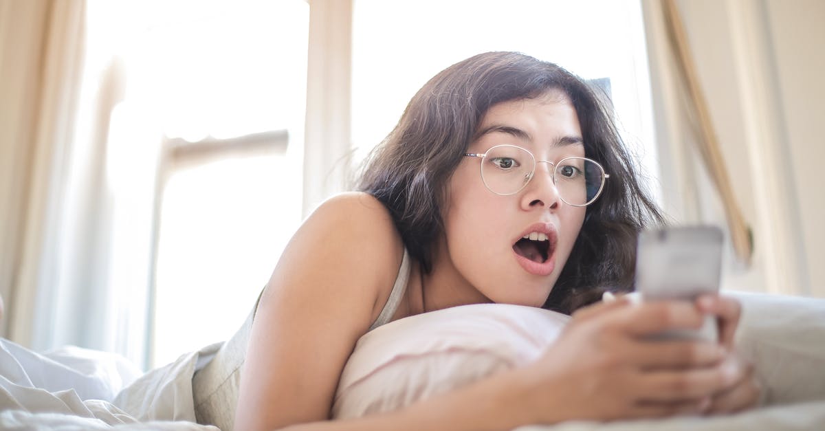 Is she lying on the phone? - Woman Lying on Bed Holding Smartphone