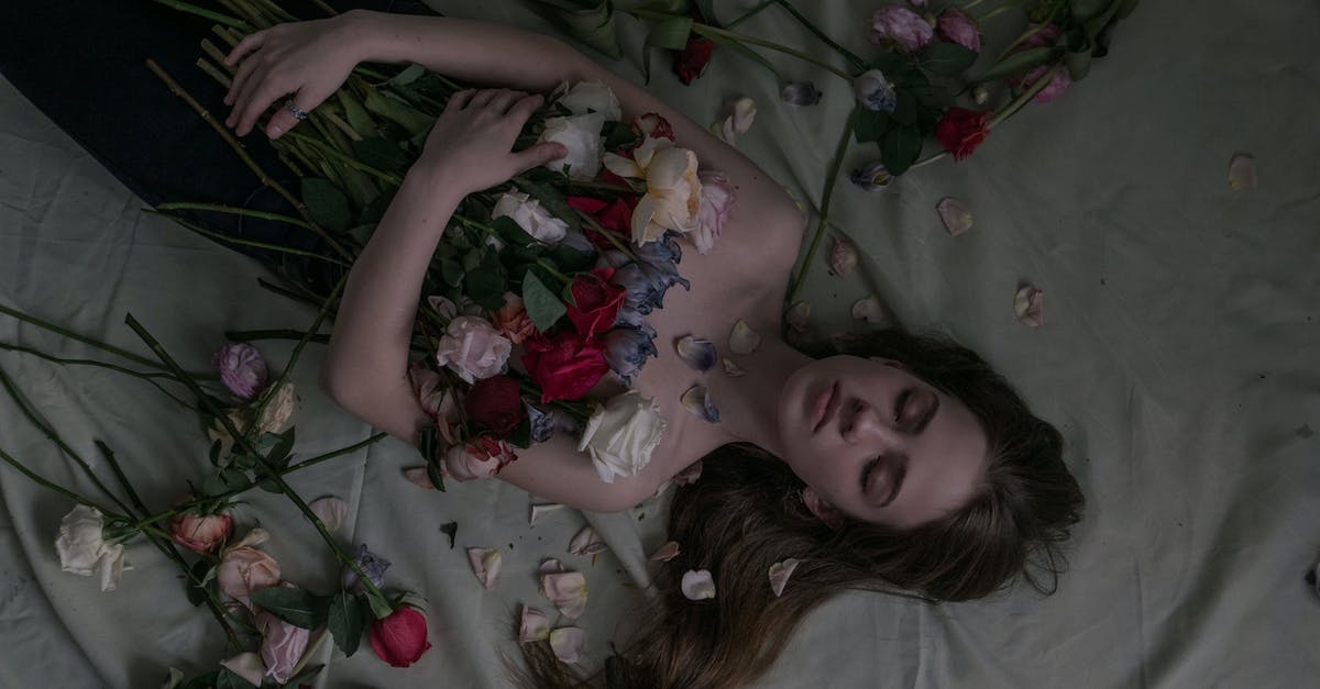 Is Thanos able to exclude individuals from his culling? [closed] - From above of charming female with long brown hair lying with colorful roses on bed in room