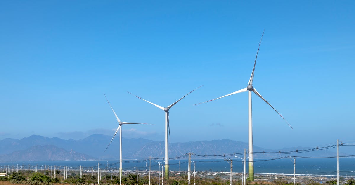 Is the Land of Ooo really a post apocalyptic Earth? - Scenery view of wind turbines in row on terrain with plants against ocean and mounts in daytime