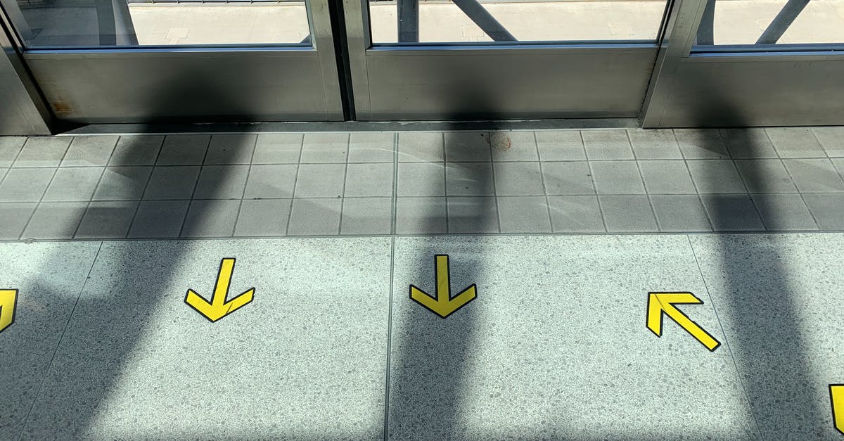Is the T2 Trainspotting airport greeter from Slovenia for everyone? - Yellow arrows on tiled floor in building