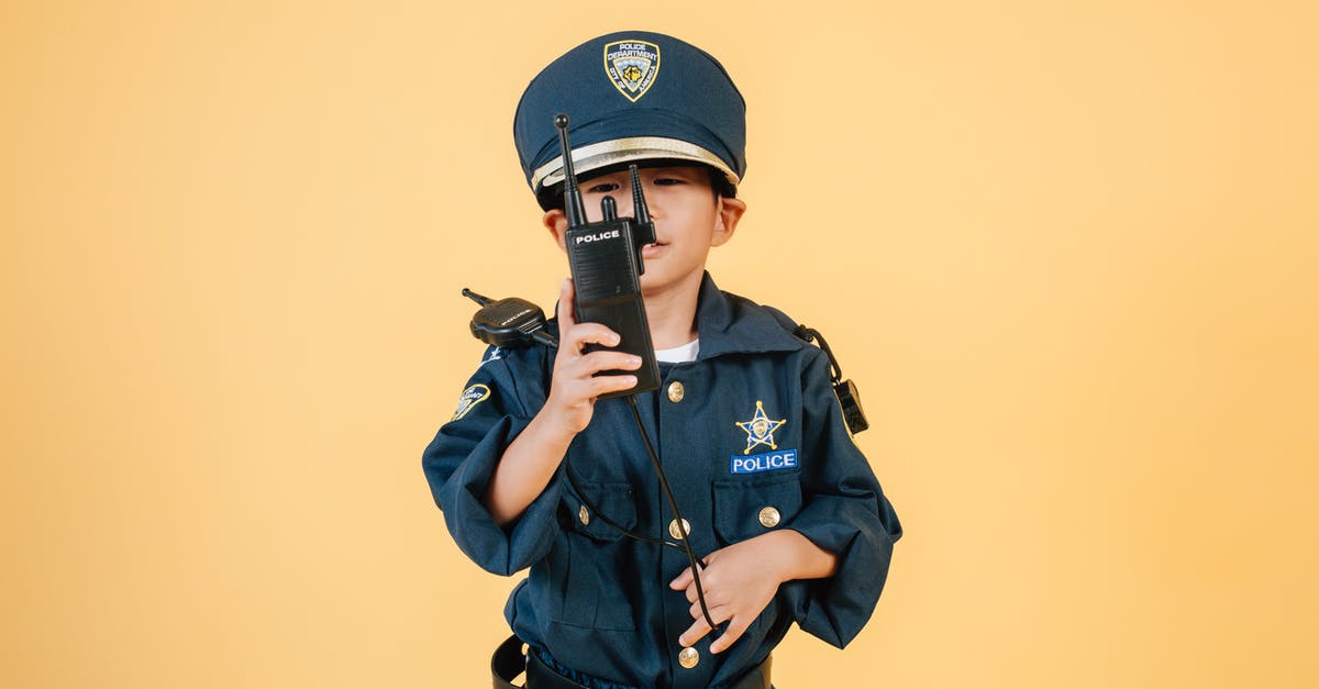 Is there a reason for the appearance of the kid with the toy gun in the supermarket? - Asian boy in police uniform against yellow background