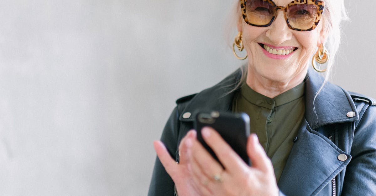 Is there an explanation behind vampires not using glamour for turning? - Crop happy senior female in stylish jacket touching screen of mobile phone while smiling and looking at camera