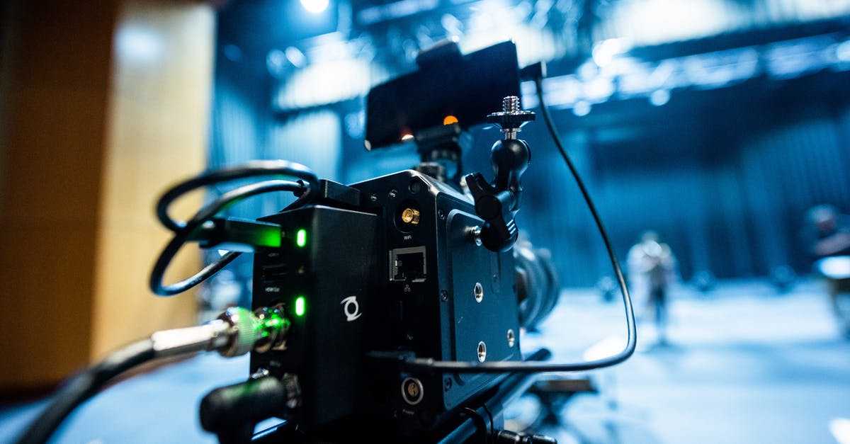 Is there an industry-specific term for the animated logo that precedes a movie studio’s films? - Professional black video camera with wires located in professional recording studio during process of filming