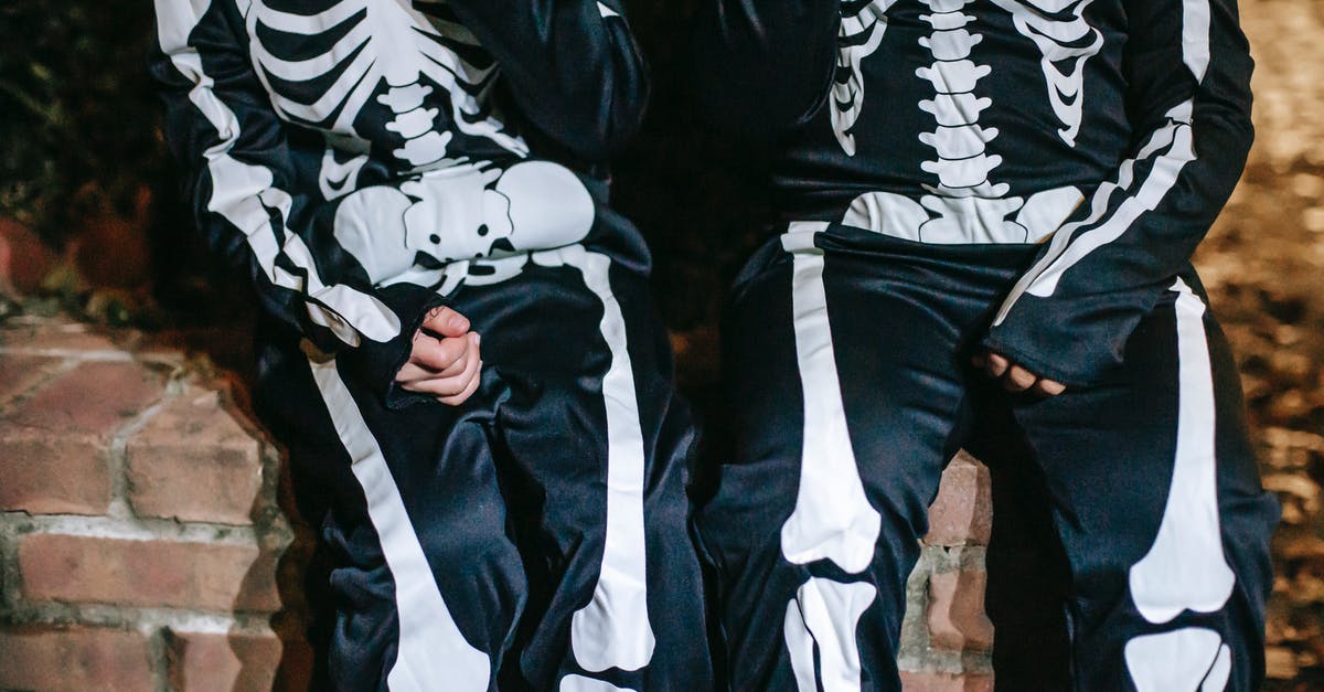 Is there any link between all of the American Horror Story series? - Crop anonymous kids in costumes with skeleton print resting during festive event in autumn at dusk