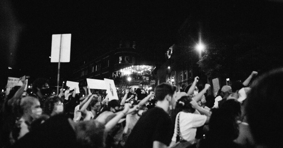Is there anything to be said about the fact that Bane's mask is the negative of Batman's? - Side view of black and white anonymous aggressive demonstrators with fists up during protest on street at night
