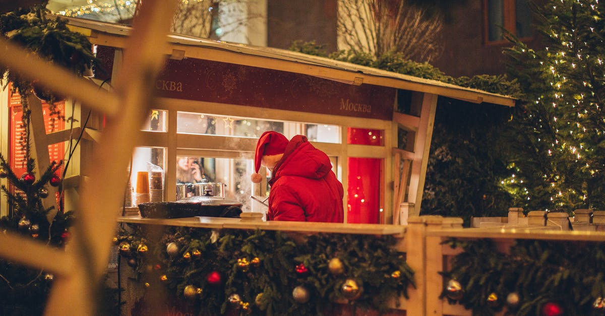 Is there going to be a 3rd season of V? - Back view of male wearing warm outerwear standing near counter at Christmas fair while enjoying holidays and purchasing takeaway beverage in illuminated city