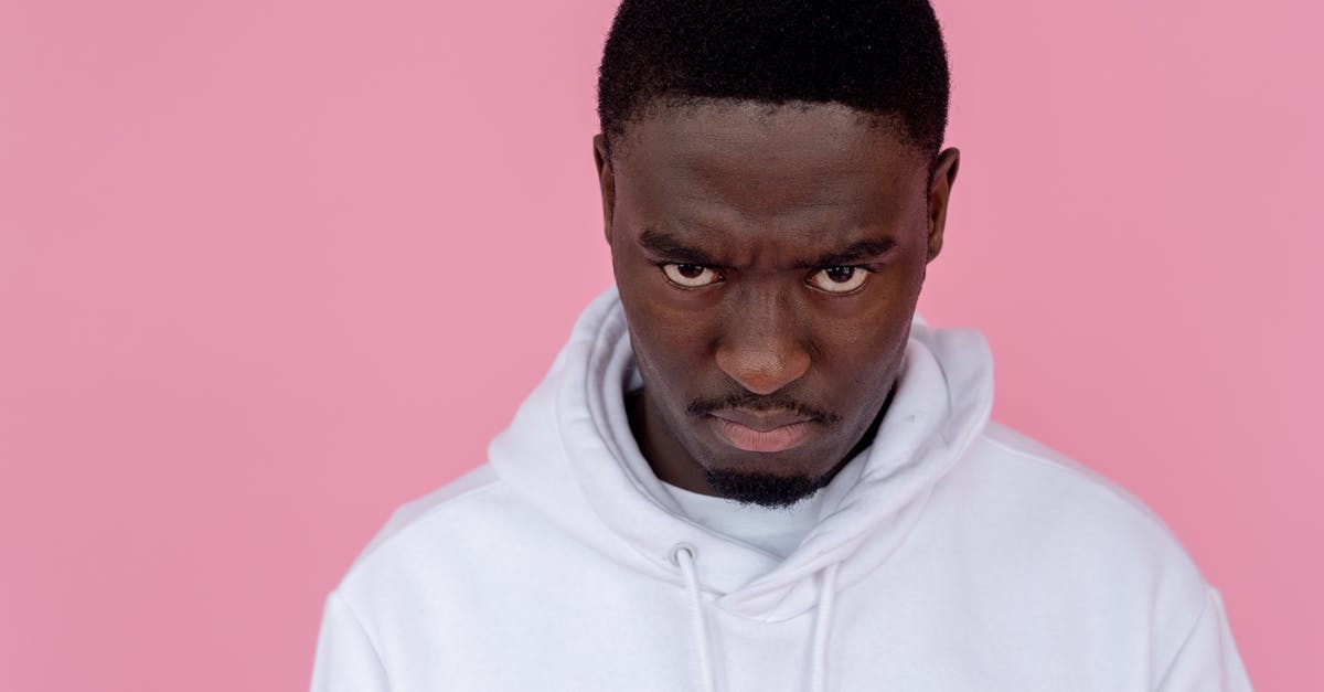 June's behavior with the Waterfords - Angry black man in hoodie against light pink background