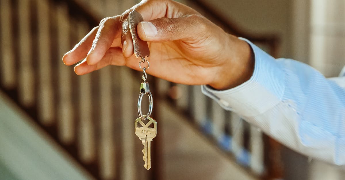 Keys to Monika's apartment - Person Holding a Silver Keychain with a Key