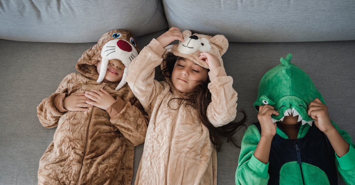 Kids in a post-apocalyptic world playing a hockey-like game [closed] - Three Kids in Animal Costumes Lying on Grey Sofa