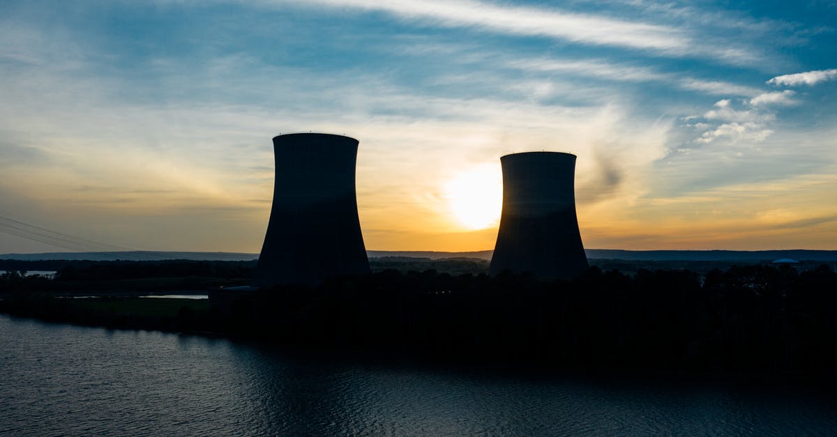 Last scene of Willy Wonka & the Chocolate Factory - Identical cooling tower silhouettes on power plant near rippled river under colorful cloudy sky at sundown