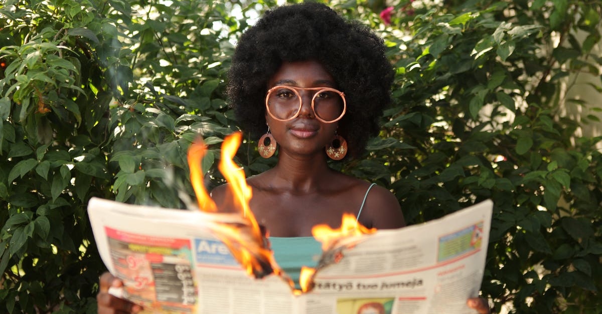 Meaning of Hannah's last appearance - Trendy black woman reading burning newspaper in garden