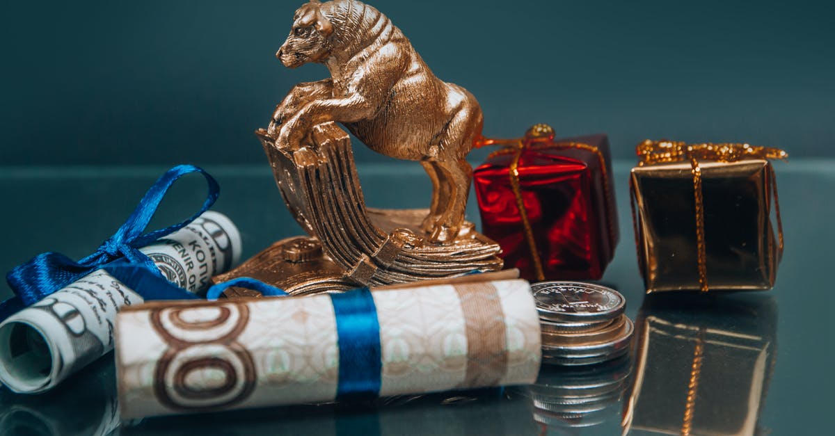 Mention of "crackers" in Zodiac - Golden ox figurine with small wrapped New Year presents composed with coins stack and rolled various banknotes